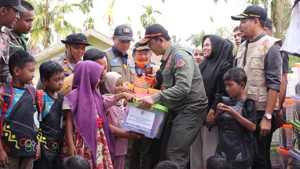 Kepala BNPB Letjen TNI Dr. Suharyanto S.Sos., M.M., (topi rompi hijau) berinteraksi dan memberikan bingkisan hadiah kepada siswa SDN Blang Seunong di Desa Meunasah, Kecamatan Pante Bidari, Kabupaten Aceh Timur, Provinsi Aceh. Dok: Istimewa.