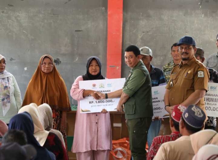 Kepala BNPB Letjen TNI Dr. Suharyanto, S.Sos., M.M (baju rompi hijau ) dan Bupati Aceh Tamiang Armia Pahmi saat menyerahkan bantuan dana tunggu hunian (DTH) kepada warga yang terdamapak bencana. Dok: Istimewa.