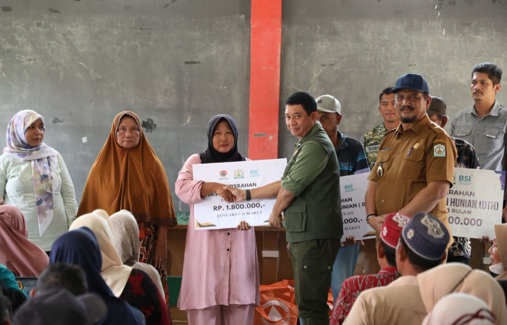 Kepala BNPB Letjen TNI Dr. Suharyanto, S.Sos., M.M (baju rompi hijau ) dan Bupati Aceh Tamiang Armia Pahmi saat menyerahkan bantuan dana tunggu hunian (DTH) kepada warga yang terdamapak bencana. Dok: Istimewa.