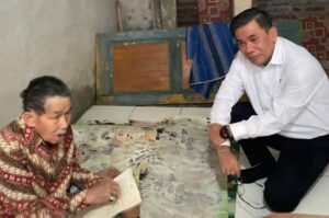 Kepala Kantor Wilayah BPN Provinsi Banten, Harison Mocodompis, menyerahkan langsung sertifikat tanah elektronik kepada Arifin (78), warga Desa Labuan, Kecamatan Mancak, Kabupaten Serang, yang tengah sakit. Dok: Istimewa.