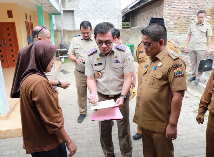 Kepala Kanwil BPN Provinsi Banten, Harison Mocodompis, menyerahkan sertipikat PTSL secara door to door kepada warga di Kelurahan Kalodran, Kota Serang. Dok: BPN Banten.