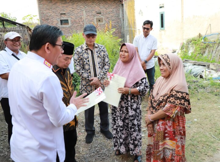 Kepala Kanwil BPN Provinsi Banten Harison Mocodompis menyerahkan sertipikat tanah secara langsung kepada warga di Desa Toyomerto. Dok: Istimewa.