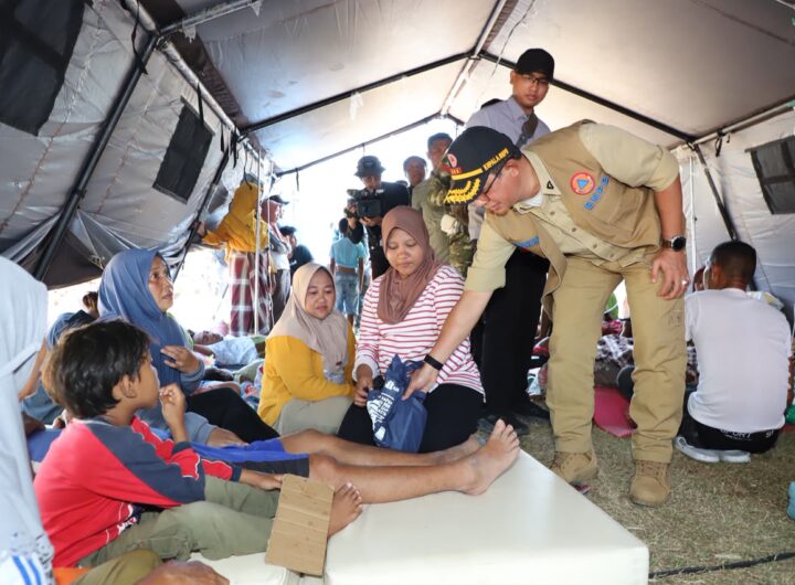 Kepala BNPB Suharyanto (topi hitam, rompi cokelat) bersama Menko PMK Pratikno (topi hitam, rompi hijau tua) berdialog dan menyerahkan bantuan logistik kepada pengungsi gempa M 7,7 Flores di Manggarai, NTT, Senin (17/8).