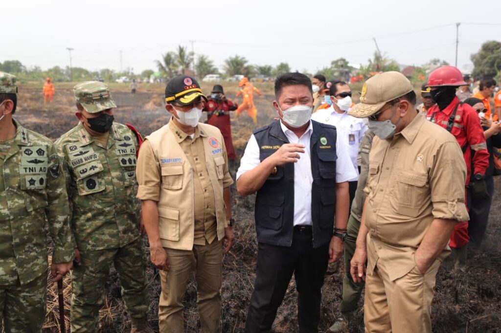 Kepala BNPB Letjen TNI Dr. Suharyanto bersama Menko Polkam Jenderal TNI (Purn.) Djamari Chaniago meninjau langsung operasi pemadaman karhutla di Kertapati, Palembang.